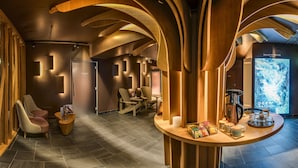 A modern lounge with wooden accents, a coffee station, and a large digital screen displaying 'DEEP NATURE'. - Center Parcs Villages Nature Paris (Villeneuve-le-Comte)