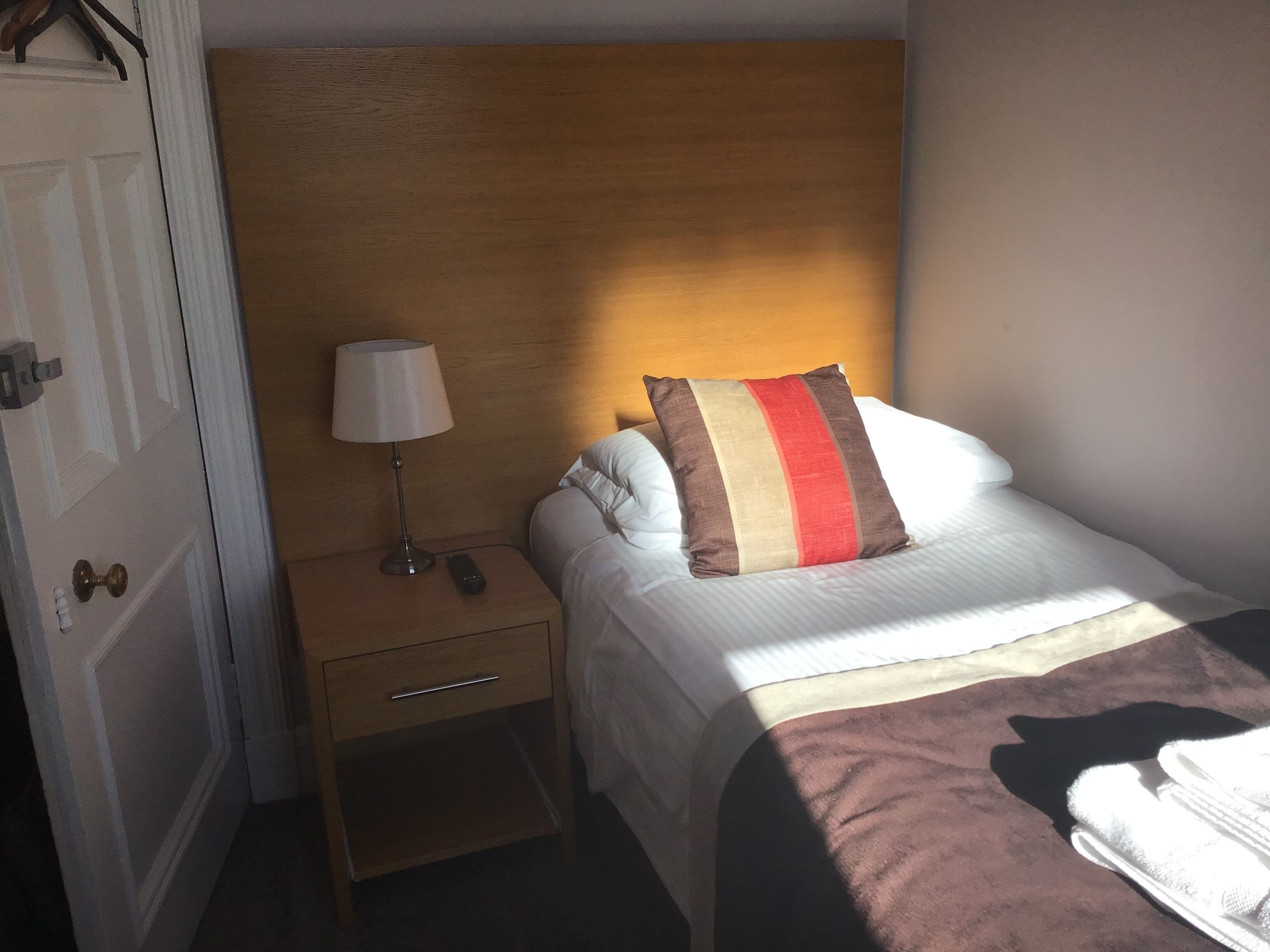 Une chambre d’hôtel avec un lit, une table de chevet avec une lampe et une petite table d’appoint.