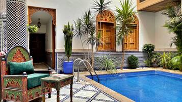Una piscina techada, sillones reclinables de piscina