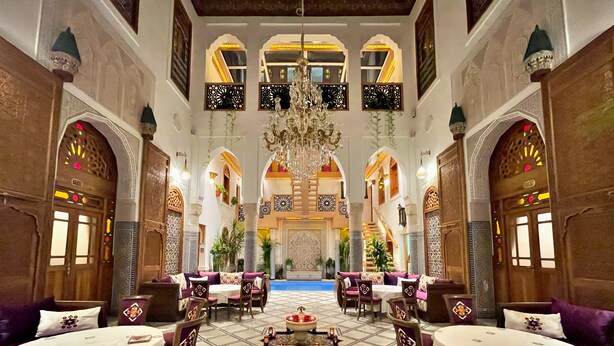 A luxurious hotel lobby with ornate arches, a central fountain, and a high ceiling with chandeliers. - Riad Marjana Suites & Spa (Fes)