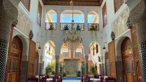 An ornate interior with a central fountain, patterned floor, and traditional furnishings. - Riad Marjana Suites & Spa (Fes)
