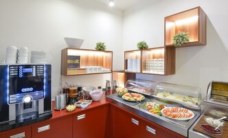 Un'area buffet con una macchina da caffè, diverse opzioni alimentari e un angolo caffè.