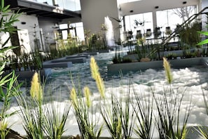 Experience serenity amidst lush greenery and a soothing waterfall.