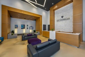 A modern reception area with a reception desk, seating arrangements, and artwork on the walls. - Hotel du Lac Champlain, an Ascend Collection Hotel (Venise-en-Quebec)