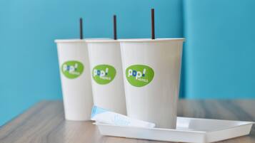 Three paper cups with 'pop! hotels' branding and a tray with a napkin labeled 'Sugar'.