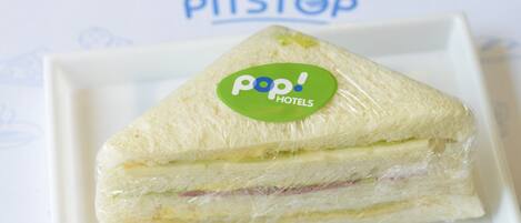 A sandwich with a 'Pop! Hotels' logo on a white plate.