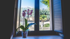 Una ventana con vistas a una montaña y palmeras.