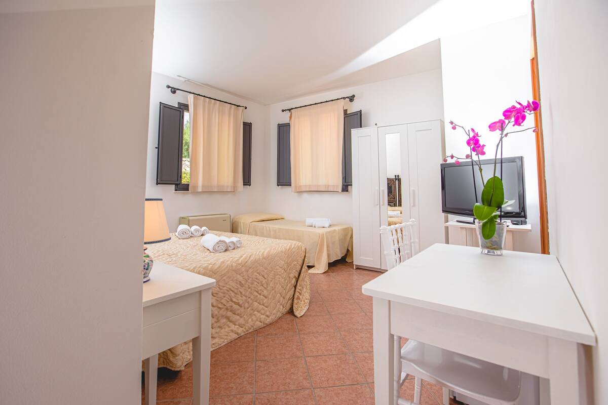 Une chambre d’hôtel avec deux lits, un bureau, une télévision et une salle de bain.