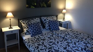 A bedroom with a bed, two bedside tables, and a wall-mounted picture. - Ferienwohnung Zacharias (Bad Hersfeld)