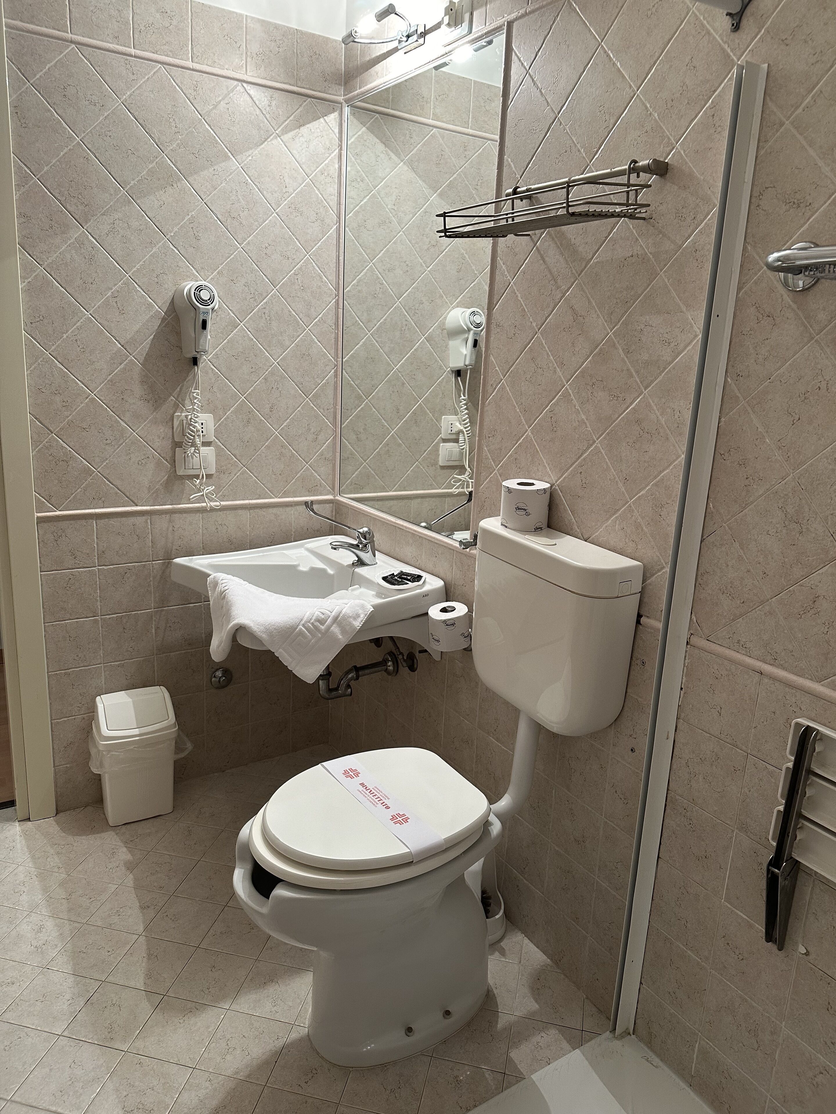 Uma casa de banho moderna com sanita, lavatório e zona de duche.