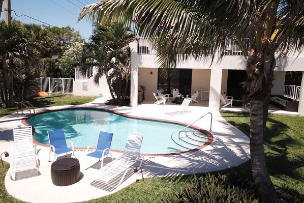 Una piscina al aire libre, sombrillas, tumbonas