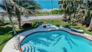 A swimming pool with a no diving sign, surrounded by palm trees and a beach view. - Southwind by iTrip Palm Beach (Singer Island)