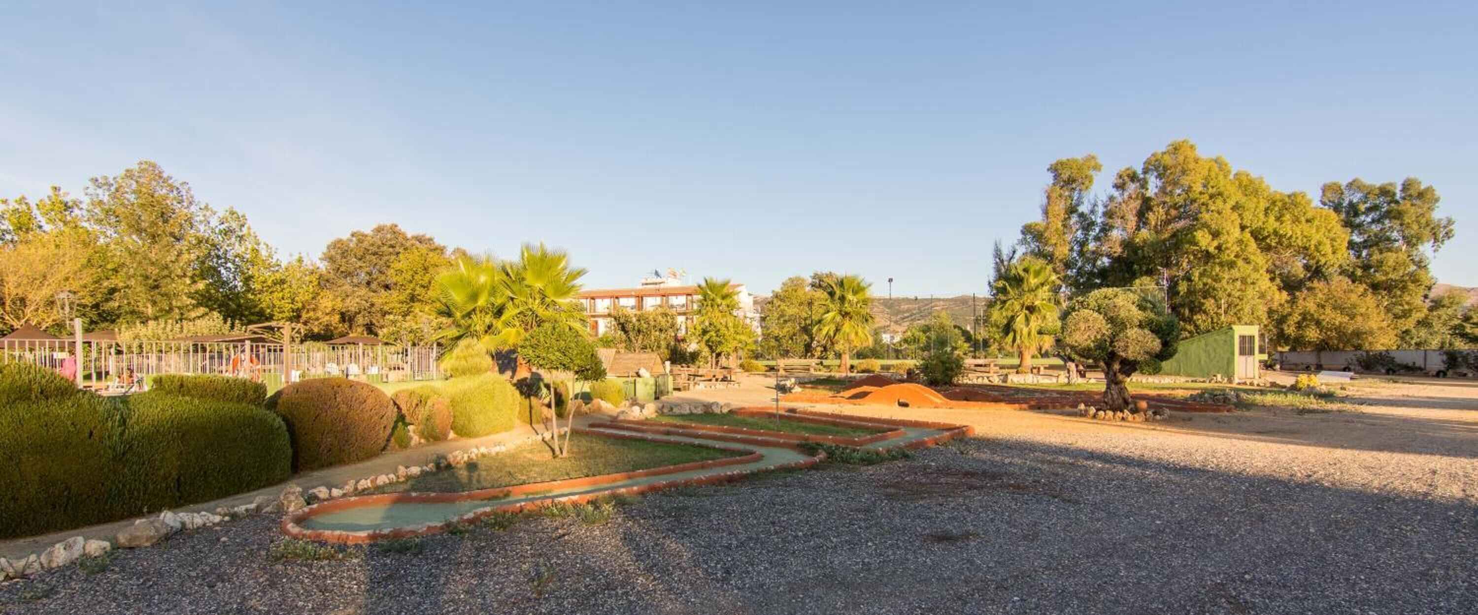 A landscaped garden with a water feature, neatly trimmed hedges, and a variety of trees.