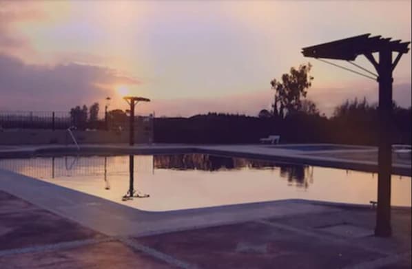 Utomhuspool, parasoller och solstolar
