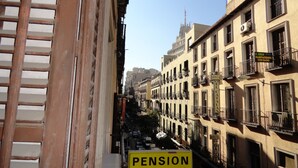 A narrow street with buildings on either side, including a sign for 'Pension Alistana' with a balcony. - Hostal Alistana (Madrid)