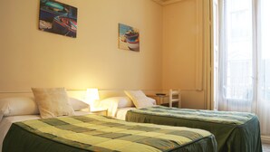 Ein Hotelzimmer mit zwei Betten, einem Nachttisch und zwei Bildern an der Wand.