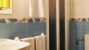 A bathroom with a shower, toilet, sink, and towels. - Hostal Alistana (Madrid)