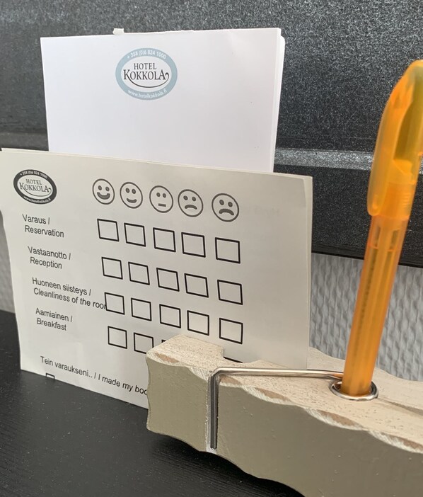 Formulario de registro de hotel con un bolígrafo insertado en un portalápices, sobre un mostrador.