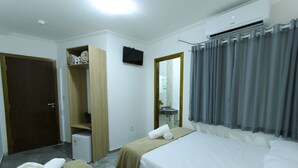 A hotel room with two beds, a wardrobe, a small desk, and a mirror. - Hotel Sabor e Fé (Aparecida)