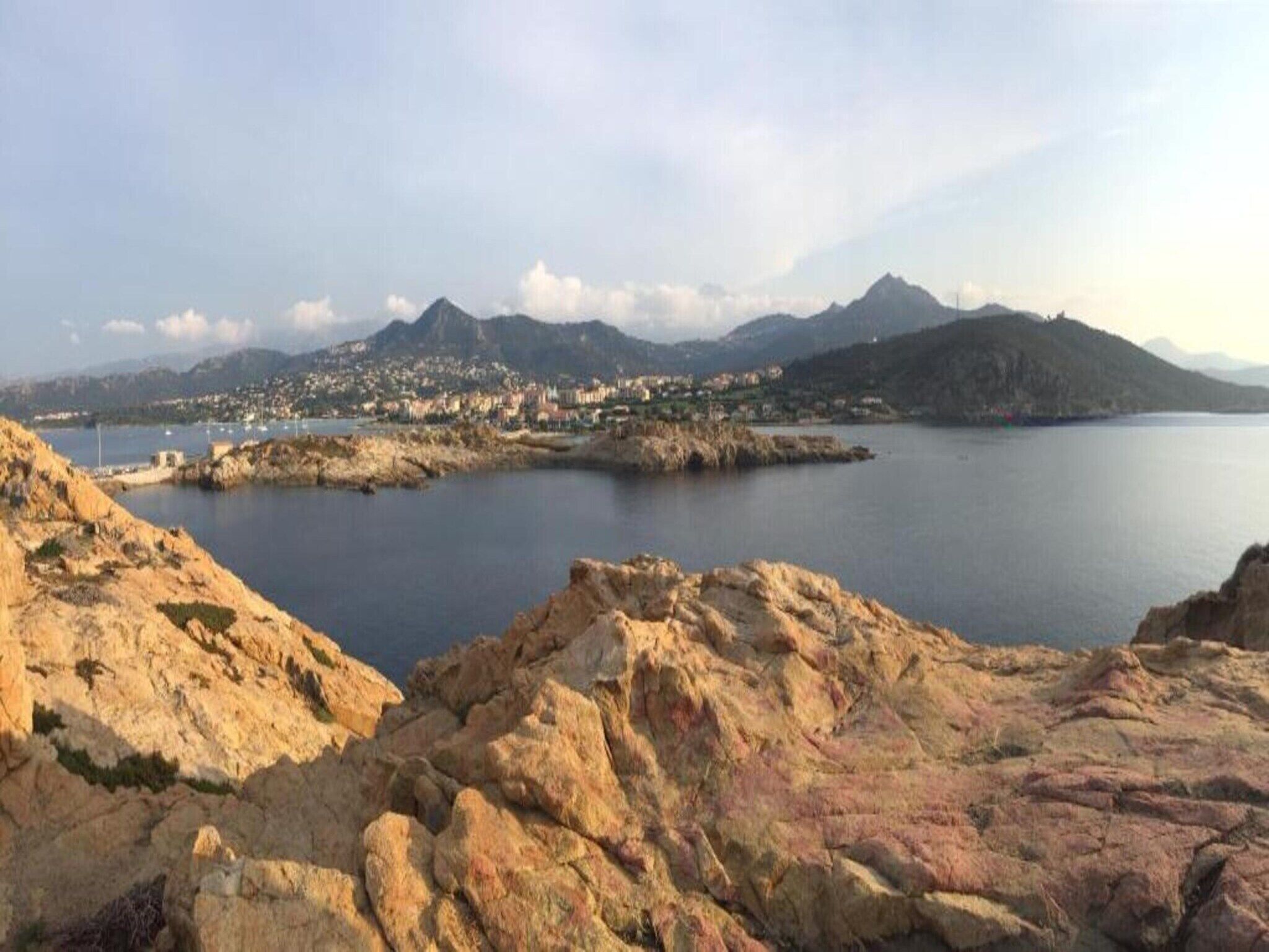 Paesaggio costiero con terreno roccioso e una distesa d'acqua.