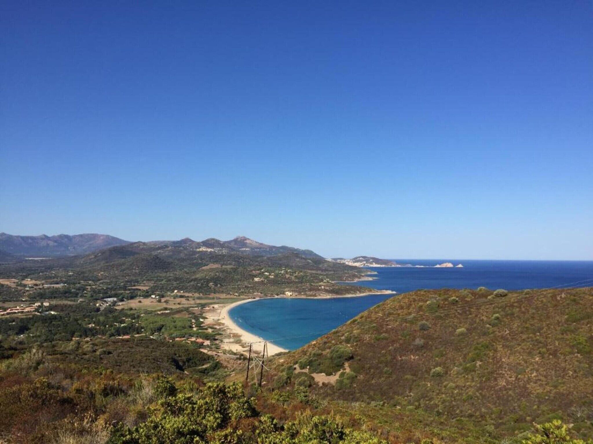 Un paisaje costero con vista despejada al mar, colinas y vegetación escasa.