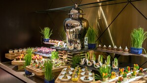 A buffet with various dishes and a large decorative pot. - Millennium Plaza Doha (Doha)