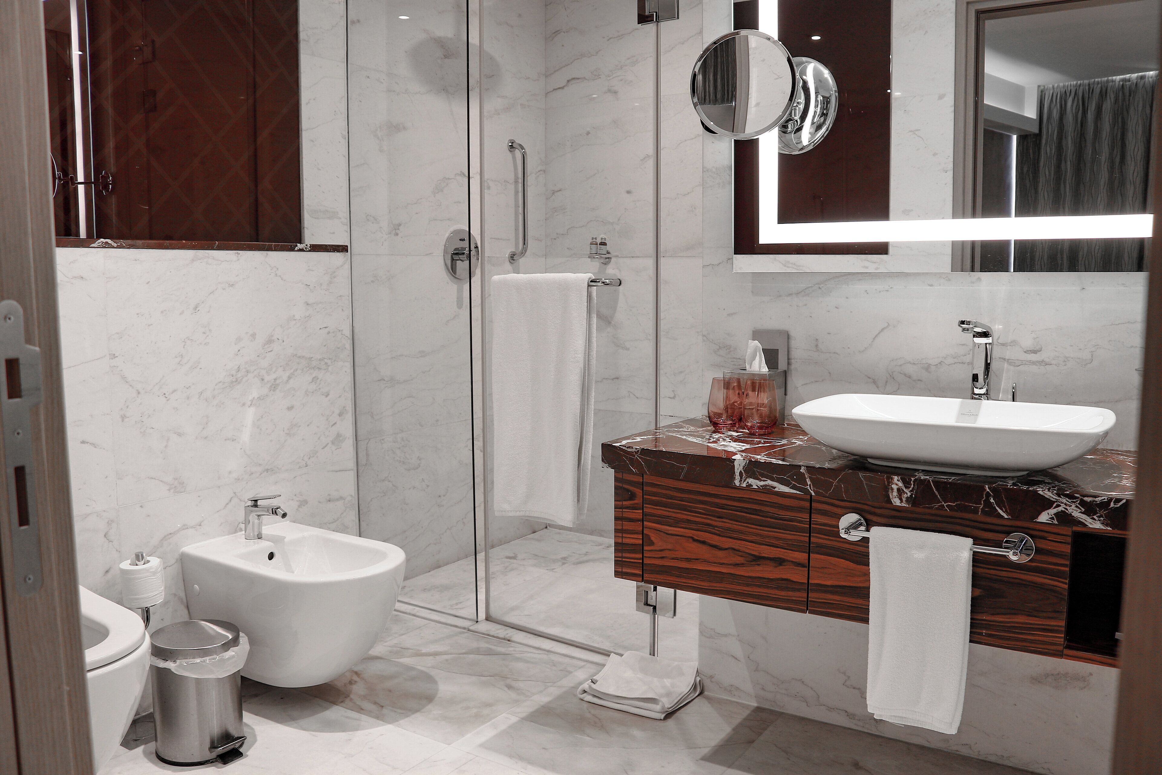 A modern bathroom with a bidet, a sink, and a mirror.