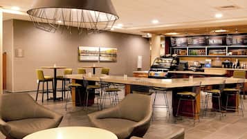 Enjoy a meal at our restaurant, where a central bar area offers a variety of seating options and a self-service beverage station.