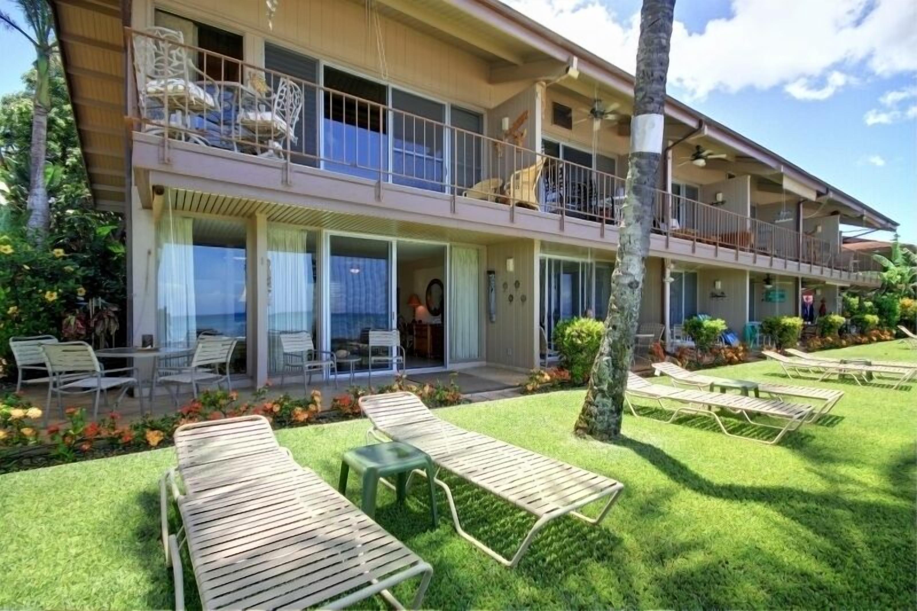 A two-story hotel with outdoor seating and a balcony.
