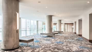 Experience the sleek, contemporary lobby with large columns, patterned carpet, and comfortable seating areas.