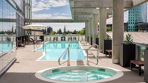 A rooftop pool with a hot tub, lounge chairs, and a view of the cityscape. - Civic Hotel Autograph Collection (Surrey)