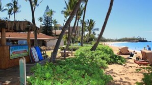 A beach rental area with a signboard, beach chairs, and umbrellas. - Maui Kaanapali S #b233 1 Bedroom Condo by RedAwning (Lahaina)