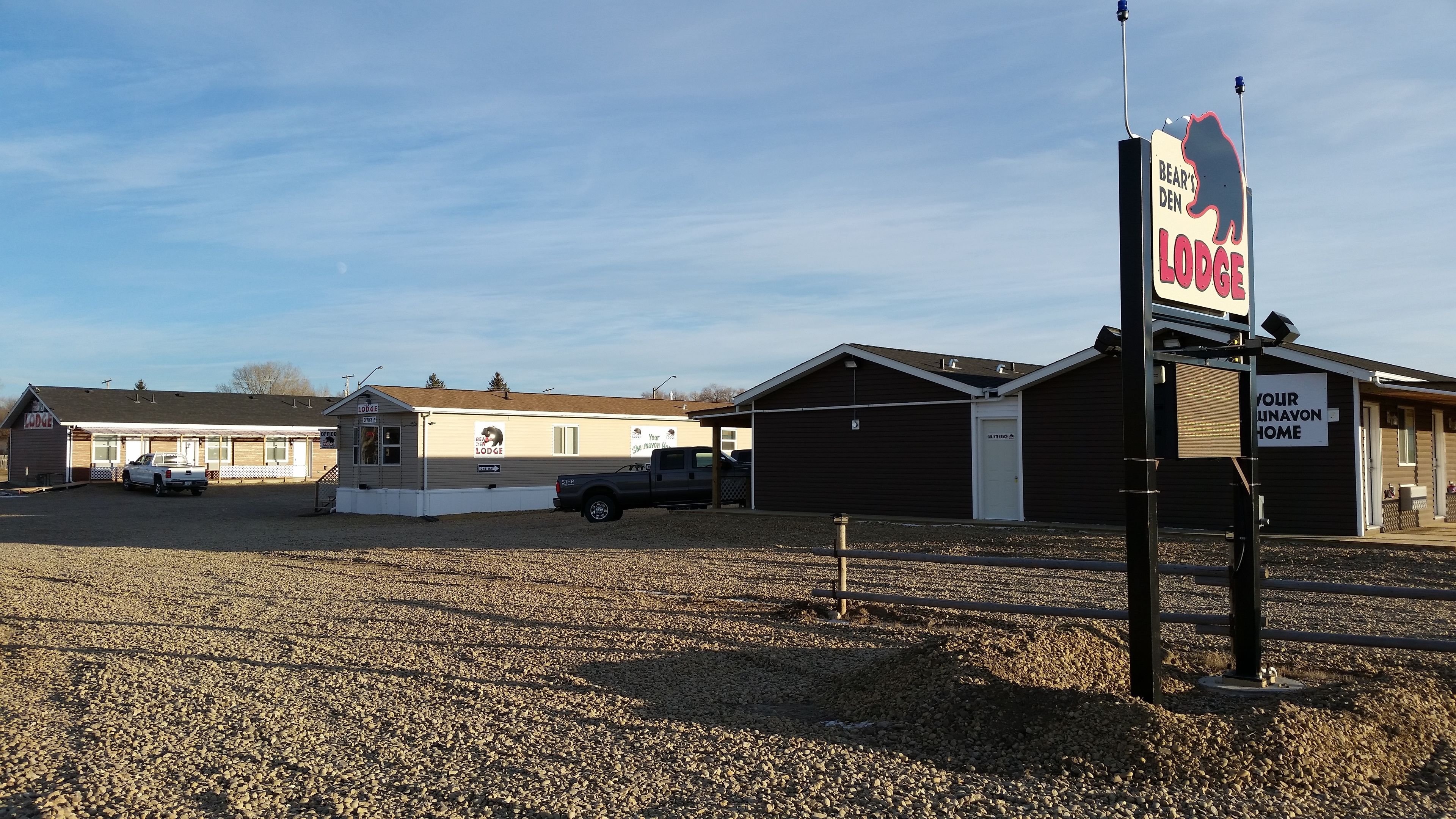 A building labeled 'Bear's Den Lodge' with a sign indicating 'Your Unavon Home'.