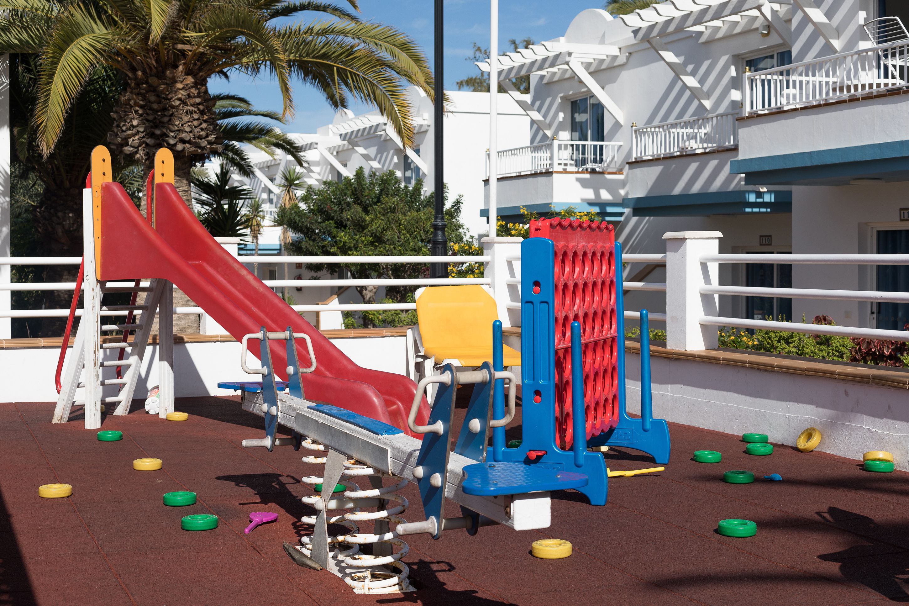 Une aire de jeux avec un toboggan, des structures d’escalade et des appareils de musculation.