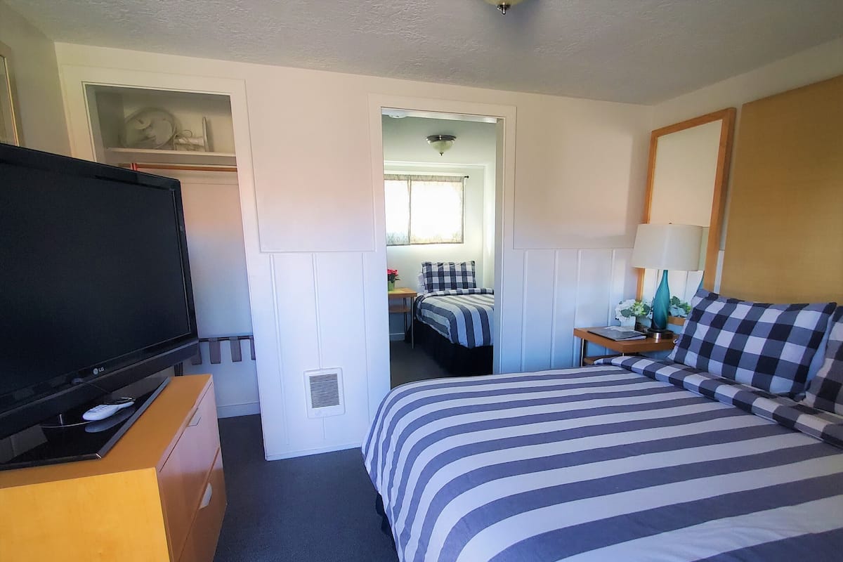 Una habitación de hotel con cama, televisión, escritorio y ventana.