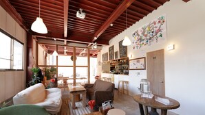 Un ambiente acogedor con muebles de madera, una zona de bar y un menú en pizarra.