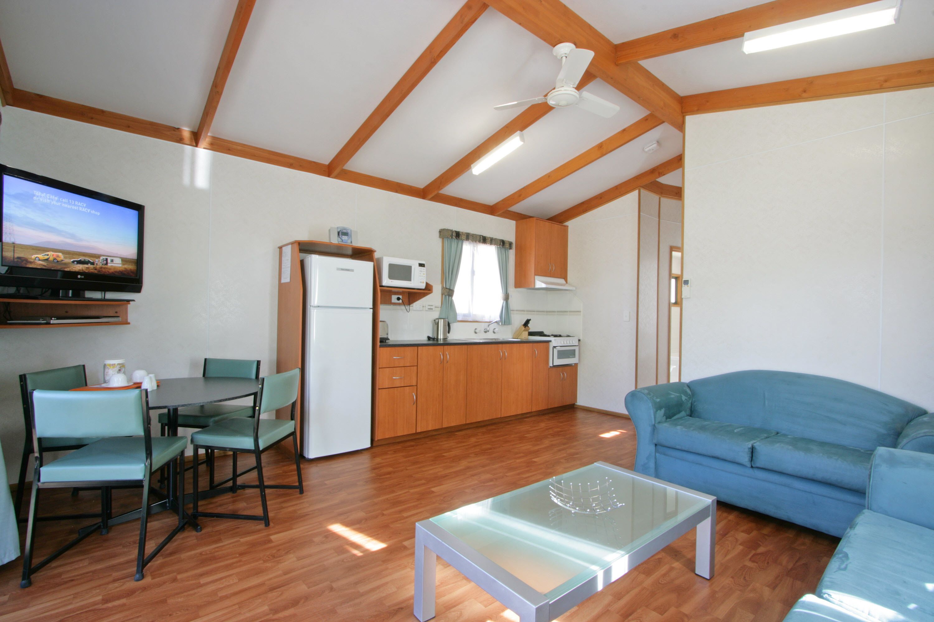 A compact living space with a dining area, kitchenette, and a sofa.