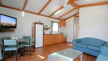 A compact living space with a dining area, kitchenette, and a sofa.