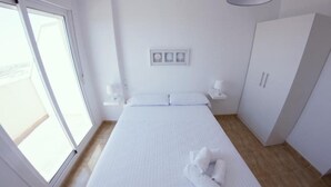 A hotel room with a large bed, a wardrobe, a bedside table, and a window. - Apartamentos H3 Laguna Playa (Roquetas de Mar)