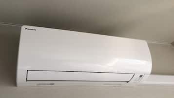 Unidade de ar condicionado Daikin branca fixada na parede.