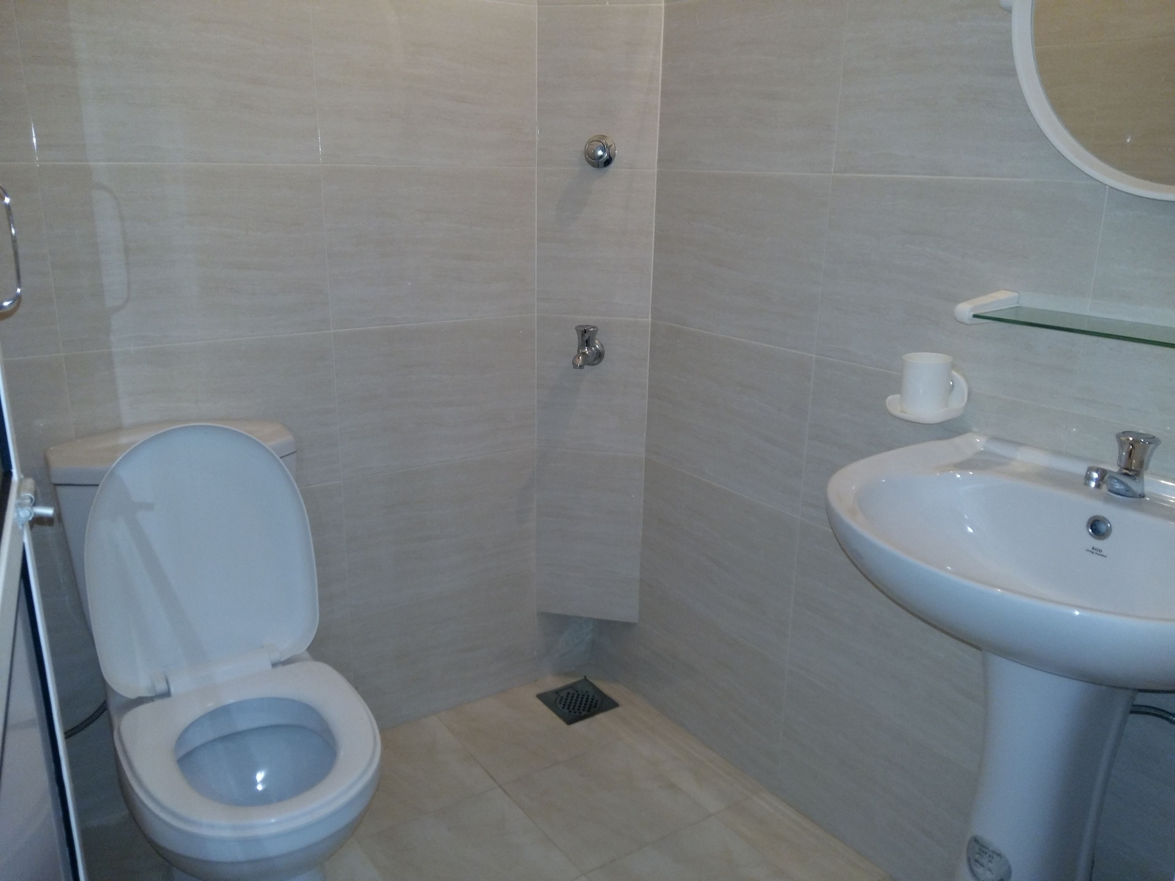 A bathroom with a toilet, sink, and shower.