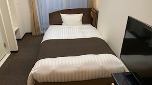 A hotel room with a bed, a television, and a window with curtains. - Tachikawa Urban Hotel Annex (Tachikawa)