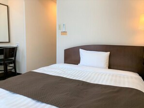Una habitación de hotel con cama, una silla y un escritorio.