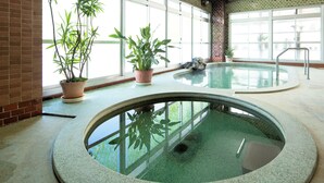 An indoor swimming pool with a brick wall and large windows. - Yunoyado Mochizuki (Myoko)