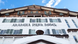 The exterior of the Akakura Park Hotel with a traditional wooden facade and a clear blue sky in the background. - Yunoyado Mochizuki (Myoko)