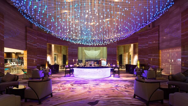 A spacious lobby with a central reception desk, seating arrangements, and a ceiling adorned with hanging lights. - Sanya Visun Royal Yacht Hotel (Sanya)