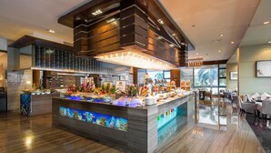 A modern hotel lobby with a central reception desk, a large aquarium, and a dining area with tables and chairs. - Sanya Visun Royal Yacht Hotel (Sanya)