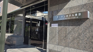 L’entrée de l’hôtel Urban Hotel Tokyo, avec une porte en verre et une enseigne.