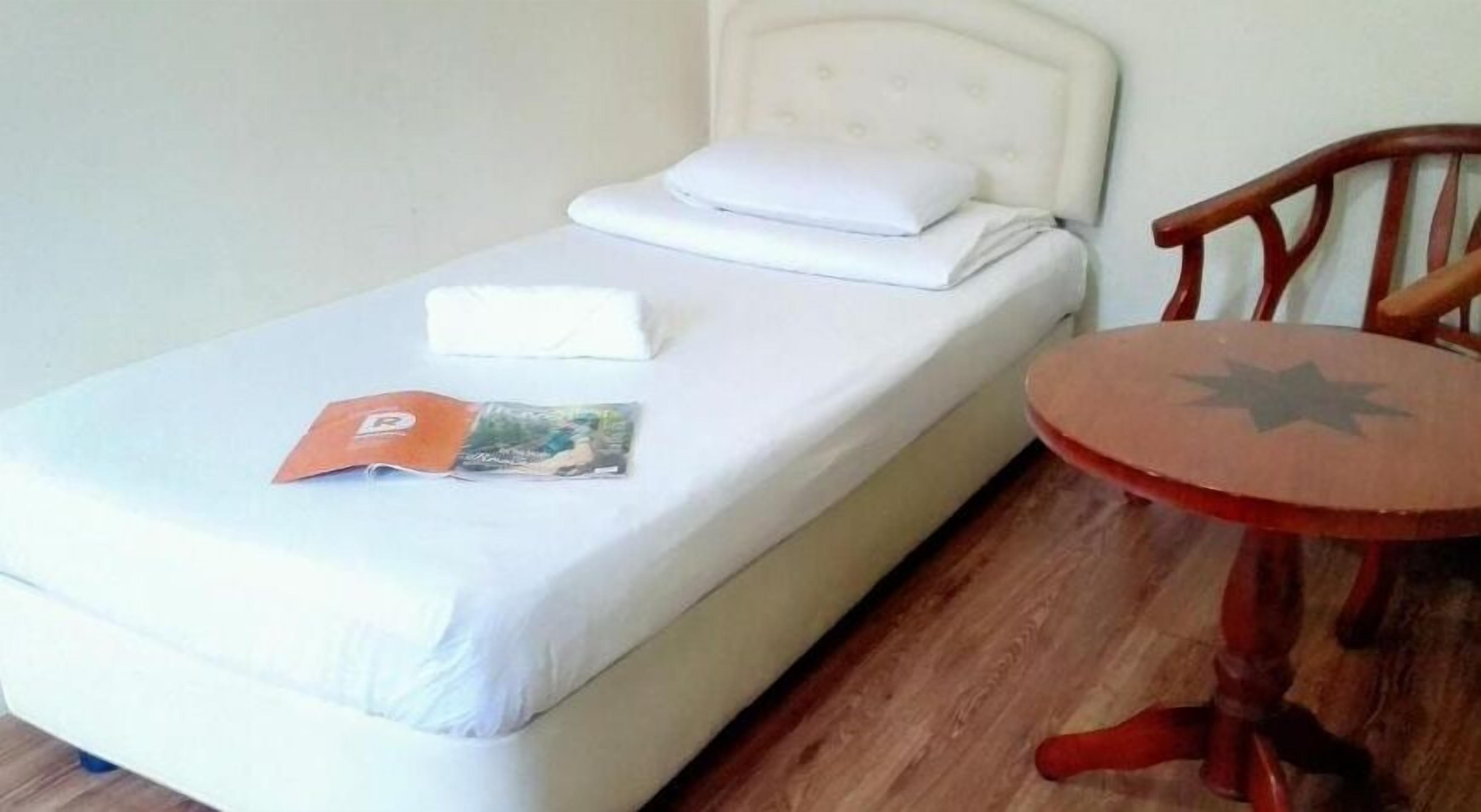 A single bed with a white headboard and a small table with a star design.