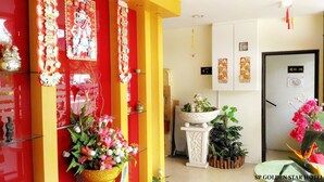 A hotel lobby with red and yellow decor, a reception desk, and various plants. - Sp Golden Star Hotel (Sungai Petani)
